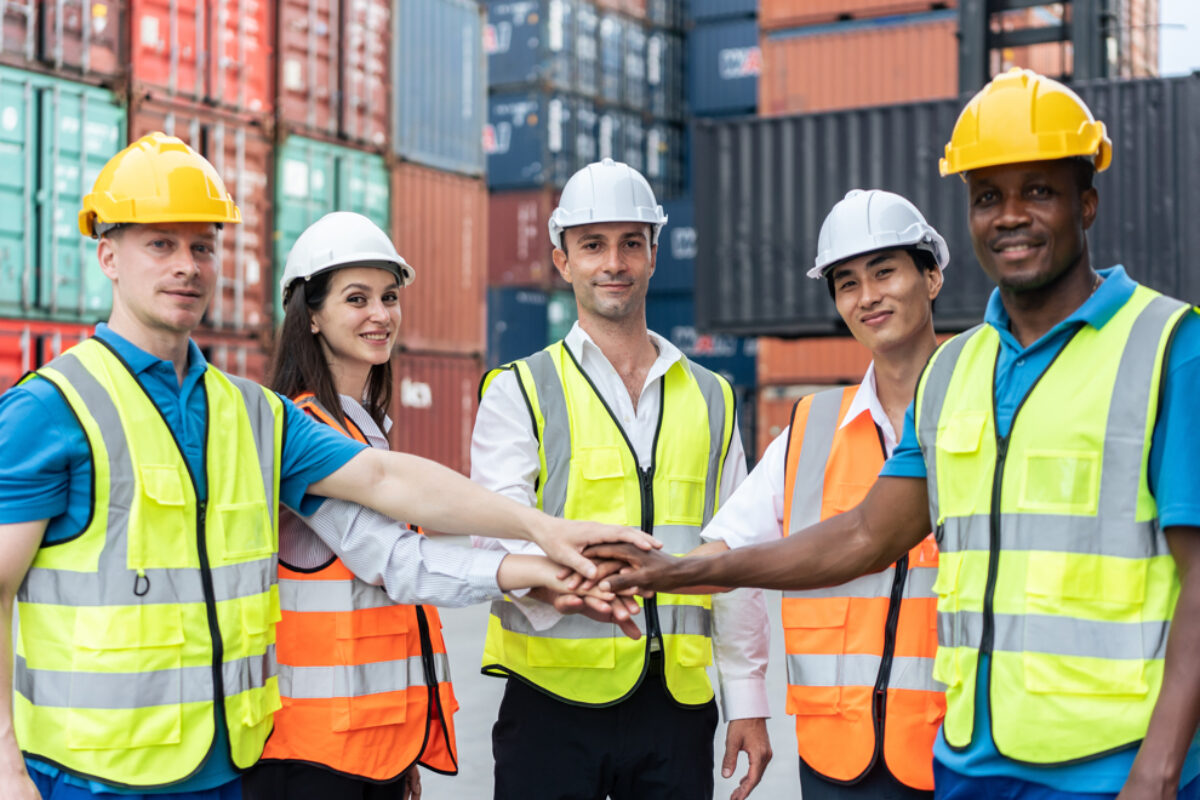 Group of man and woman worker put hand on each other in container port.